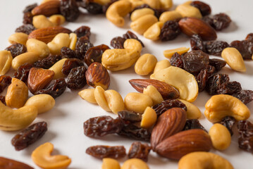 Nuts mixture of almond, cashew, peanut and raisin on table, close-up view