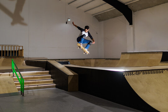 .Un chico patinando en un skatepark  indoor 