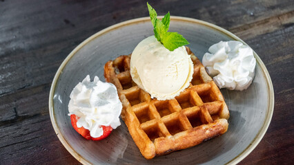 a image of a freshly prepared waffle accompanied by whipped cream and ice cream close up 