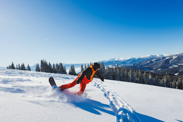 A snowboarder walks down a snowy slope in winter on the snow. Snowboarding, winter freeride