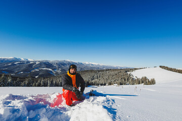 Winter sport. A snowboarder walks down a snowy slope in winter on the snow. Snowboarding, winter...