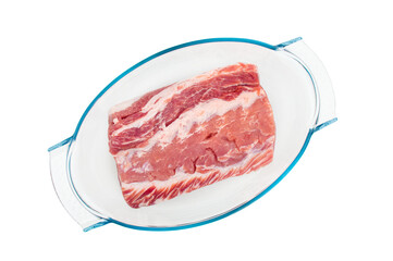Top view on raw piece of meat prepared for cooking in  glass baking container on white background