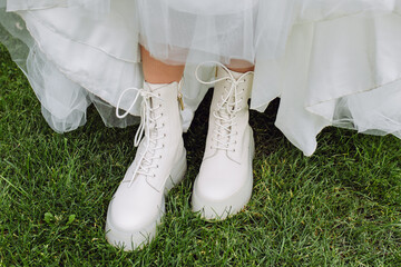 White high boots of the bride. High boots for a wedding. The bride in a white dress is standing on...