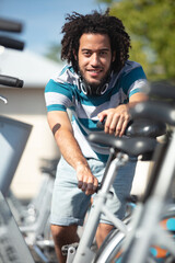 hipster man stood in row of bicycles