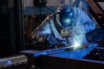 welder works with metal, mechanical engineering concept