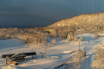 The first ray of the sun rise shining on the snow mountain in Hokkaido, Japan. 