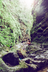 Young and beautiful woman sitting on a rock observing the nature of the valley. Travel and adventure. Nature