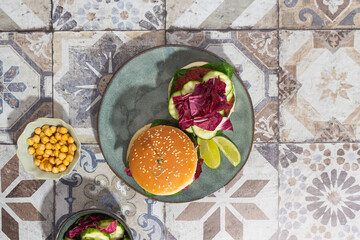 beetroot burger with lettuce and cucumber on marble background