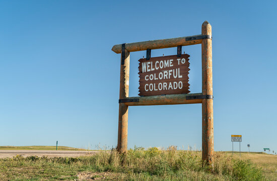 welcome to colorful Colorado roadside wooden sign at a border with Nebraska in eastern Colorado - Powered by Adobe