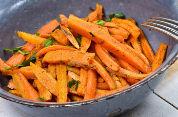 Close-up of homemade sweet potato chips in old antique bowl and silver fork.