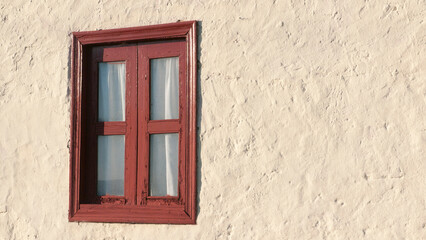 Fototapeta na wymiar Ventana con marco de madera rojo y cortina en pared de estuco blanco de casa rural