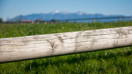 tronco de madera en valla de pradera y montañas en el horizonte,