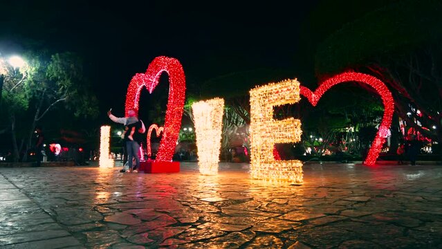 Timelapse de la palabra love, iluminada con luces y foquitos de naivdad con un coraz&oacute;n rojo 