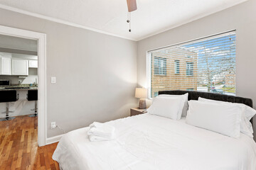 Comfortable bed, dry reeds and chest of drawers near white wall