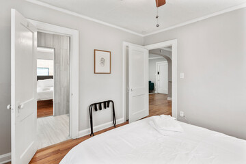 Comfortable bed, dry reeds and chest of drawers near white wall