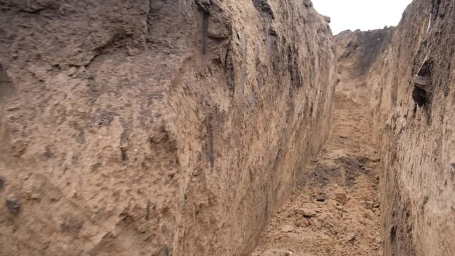 The movement of the bottom of the clay trenches that the excavator dug for the military. Russian-Ukrainian war 2022.