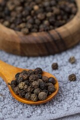 black pepper in a wooden spoon