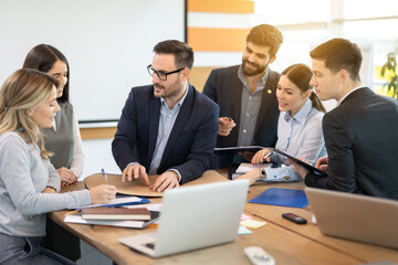 Team of executives architects working on construction plans together at desk with projects and paperwork in the office.