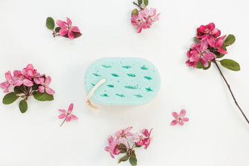 Colorful bath sponge on white floral background