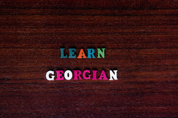 learning georgian concept. colored wooden letters of the alphabet on a wooden board