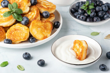 Homemade mini pancakes with sour cream and blueberries
