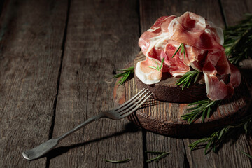 Obraz na płótnie Canvas Italian prosciutto or Spanish jamon with rosemary.