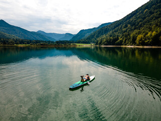 People Enjoying SUP Stand Up Paddle Boarding in Turquoise Waters in Austria