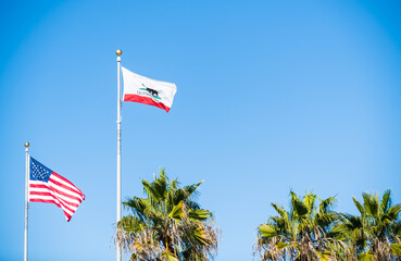 California flag and USA flag waving in the wind at the Santa Monica beach area in LA, California.
