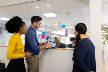 Obraz premium Diverse female and male businesspeople in office working with tablet