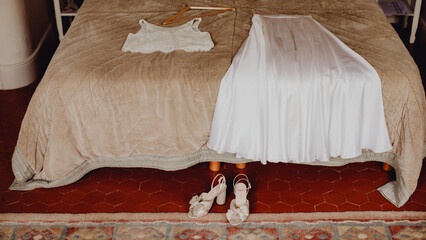 les chaussures, la jupe et le haut de la mariée sur le lit