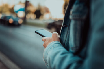 Close up photo of a man texting on a smartphone on the street