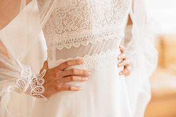 Les mains à la taille de la mariée dans sa robe blanche