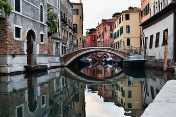 Fototapeta na wymiar Tourist attraction in Venice: reflection of venetian colourful buildings in the water canal