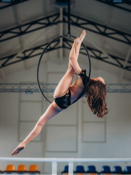 flexible teenage girl, circus artist In aerial hoop. Concept of originality, creativity and outstanding.