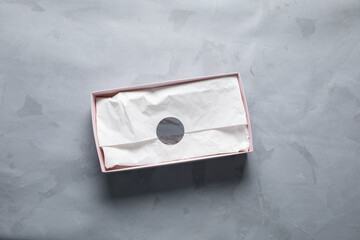 Gift box mockup on gray concrete background, top view. View from above minimalist tissue wrapping...