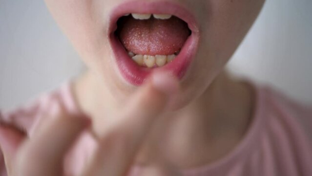 Young girl licking her fingers after eating chocolate candy