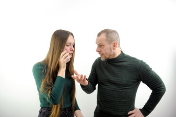 phone in hand, solve problems, litter the phone, swear Man yelling at his woman looking very mad and woman holding her head isolated on white background. High quality photo