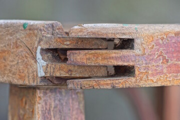 carved joint clamp on two brown old wooden planks in the structure of the chair
