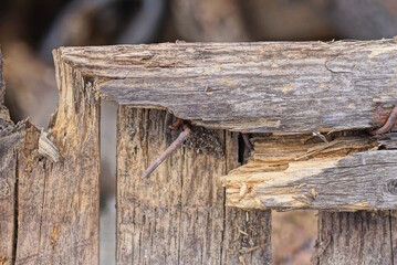 part of an old wooden fence wall made of broken gray brown planks on a rural street