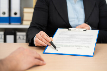 hands holding a pen and indicating where to sign