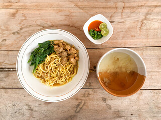 Noodle chicken soup (mie ayam) Indonesia food served on wooden table.