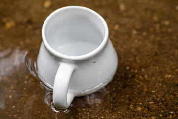 White mug, mock up, empty space for artwork, text, standing on stone, outdoors, green grass, trees, sky in the background, soft sunlight, nature