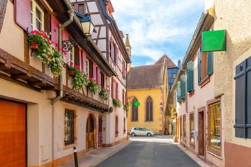 Fototapeta na wymiar One of the many picturesque and colorful streets and alleys in the medieval village of Ribeauville, in the Alsace wine region of Northeast France.