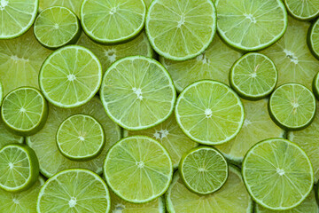 Fresh lime slices as background, top view