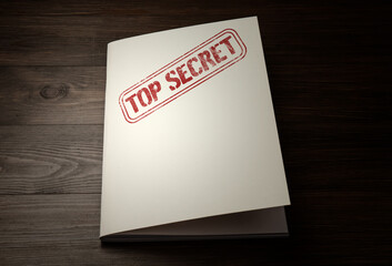 White paper brochure with Top Secret stamp on wooden table