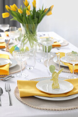 Festive table setting with glasses and vase of tulips. Easter celebration