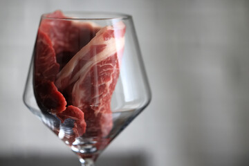 meat in a wine glass, concept idea food menu, unusual background