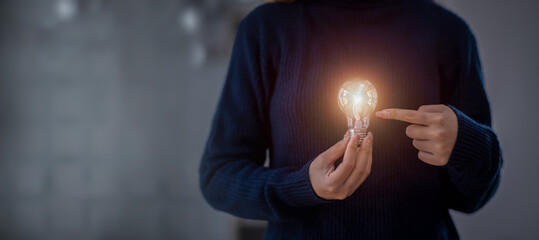 Hand holding light bulb with the light new mindset in  of the bright light