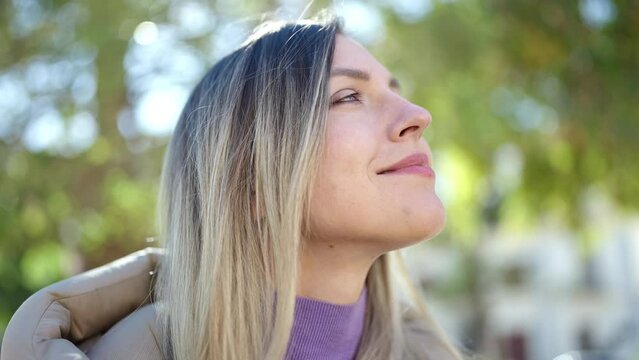 Young blonde woman smiling confident breathing at park