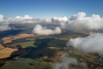 Aerial view at high altitude of earth covered with puffy cumulus clouds forming before rainstorm